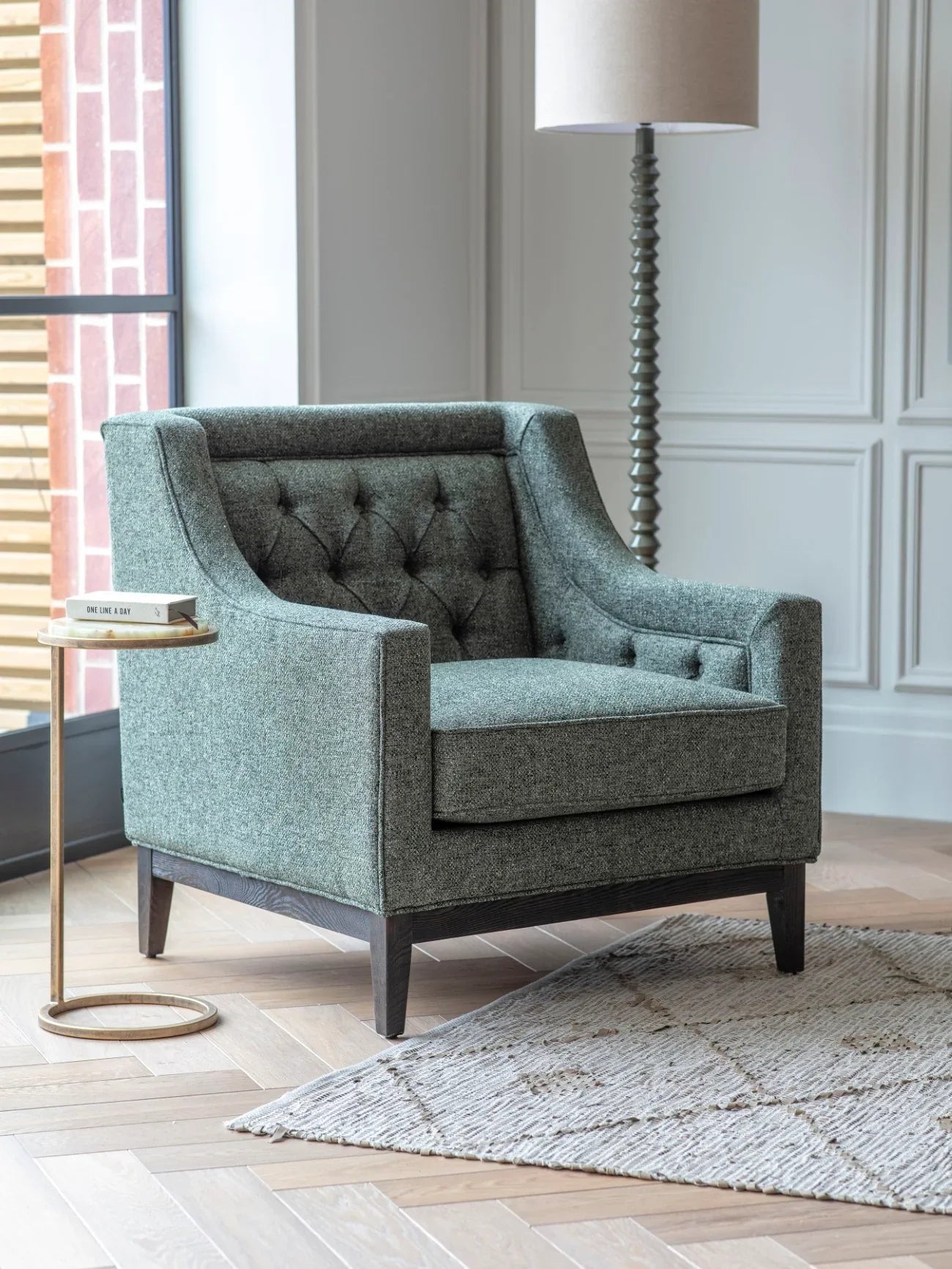 Forest green armchair in a modern room with a floor lamp and side table.