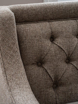 Dark taupe sofa with buttoned backrest and textured fabric detail.