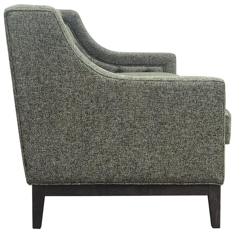 Forest green sofa side view with textured fabric and dark wooden legs.