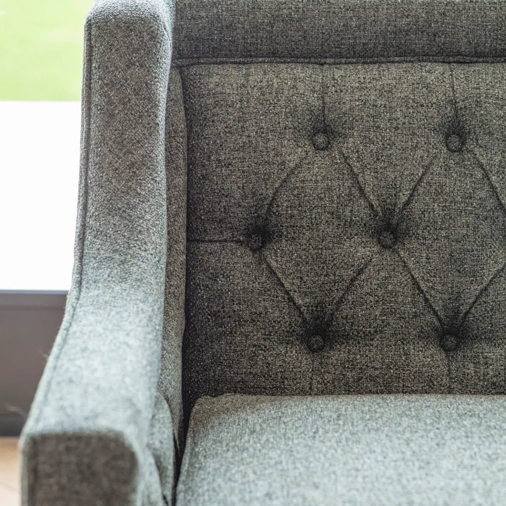 Forest green sofa with buttoned backrest and textured fabric.