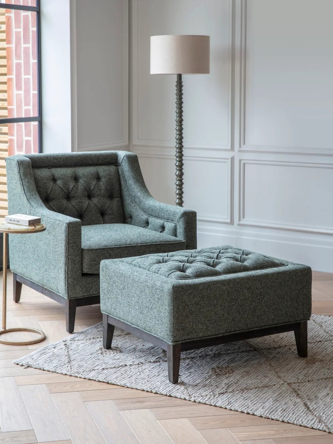 Forest green buttoned stool in elegant living room with matching armchair.