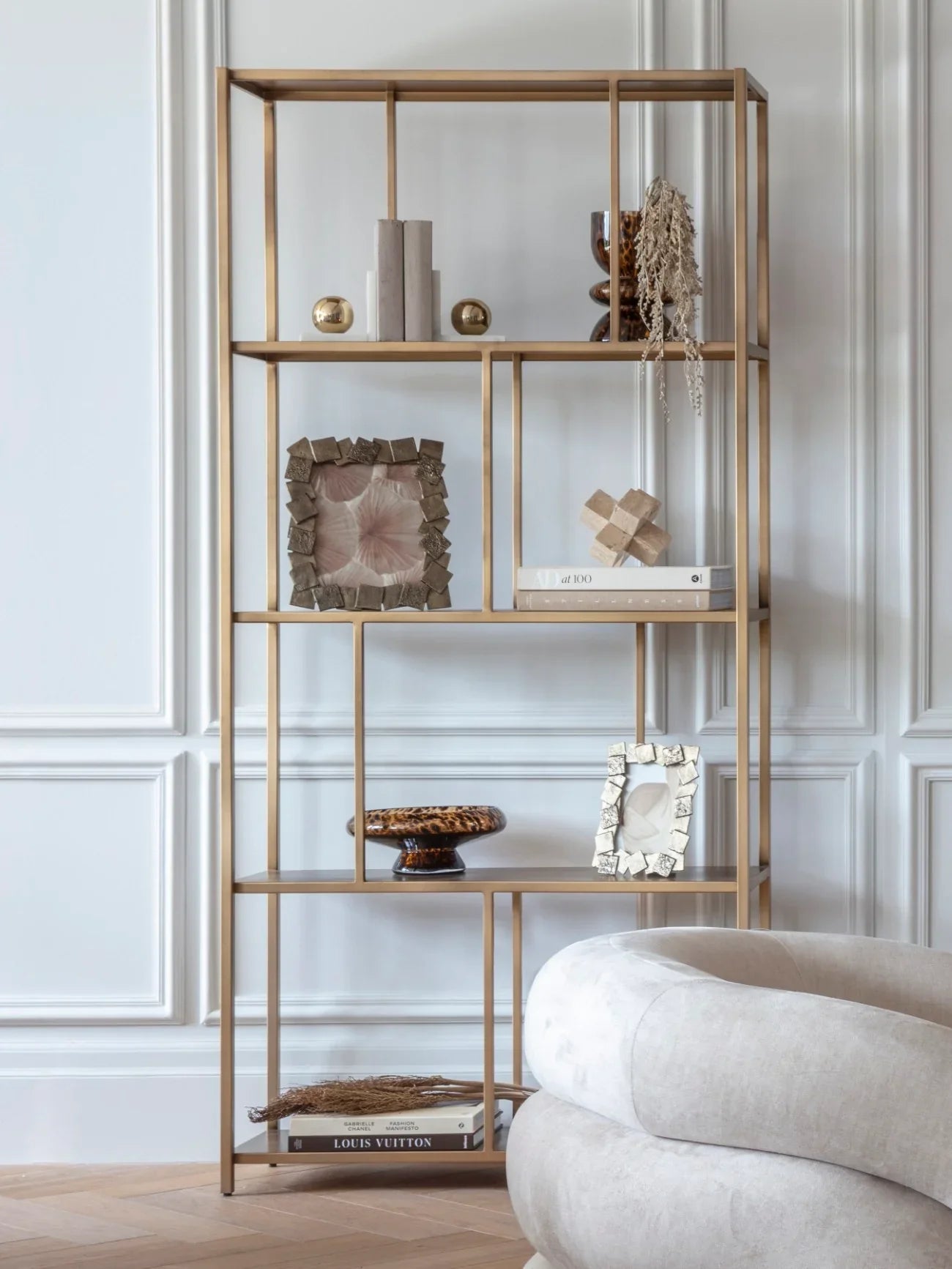 Brushed champagne shelving with decor in elegant living room setting.