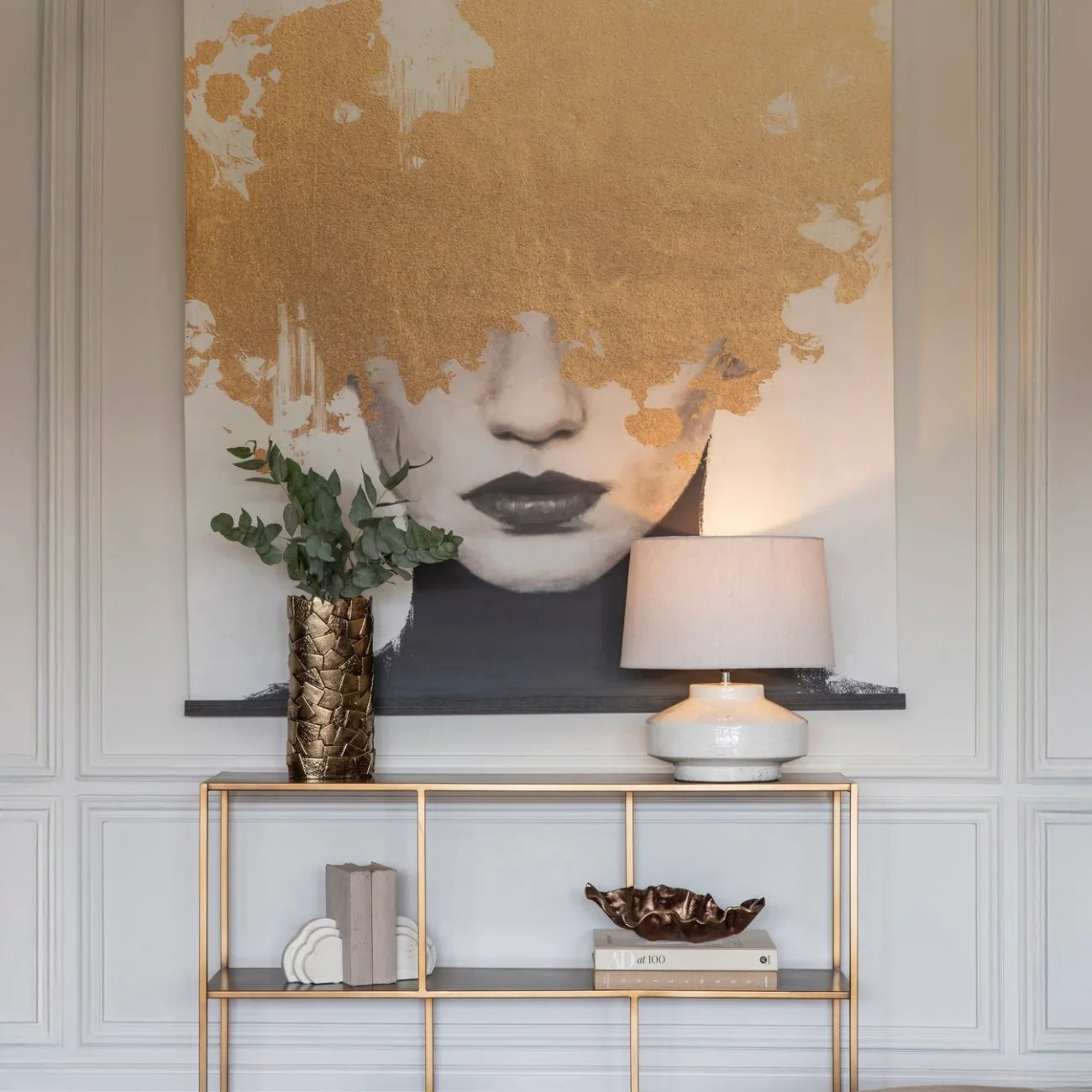 Brushed champagne console table with decor in elegant living room setting.