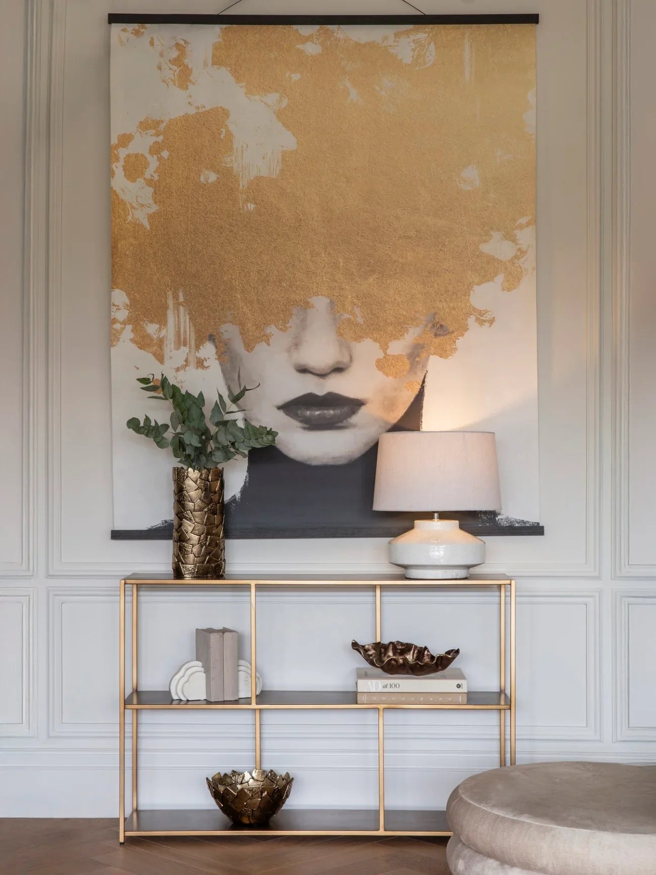 Brushed champagne console table with decor in elegant living room setting.