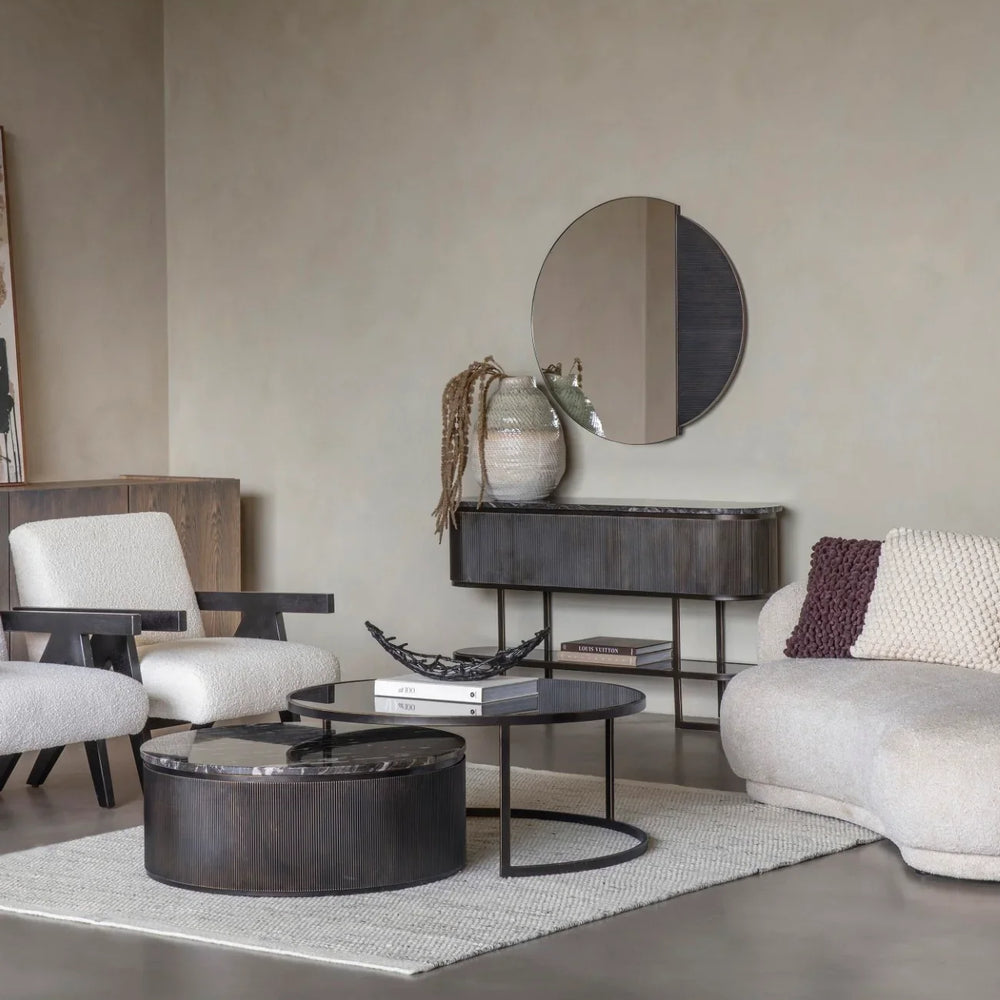 Black nesting coffee tables in modern living room with beige sofas and decor.