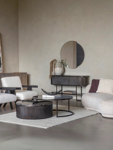 Black nesting coffee tables in modern living room with beige sofas and decor.