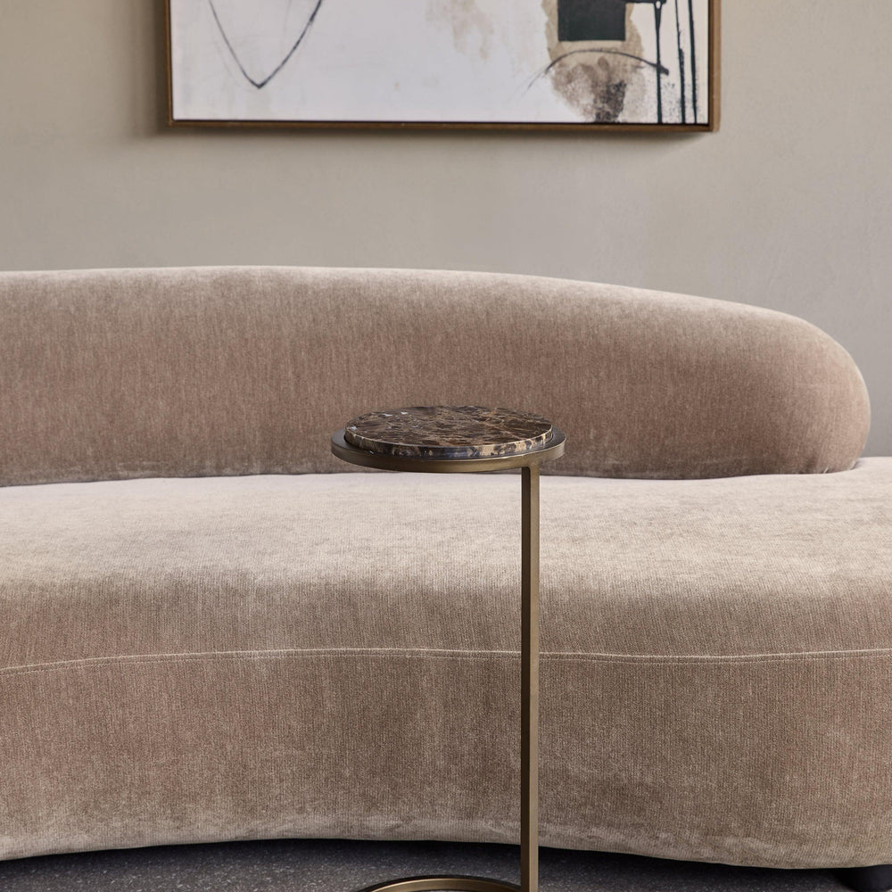 Brown marble accent table beside a beige sofa in a modern living room.