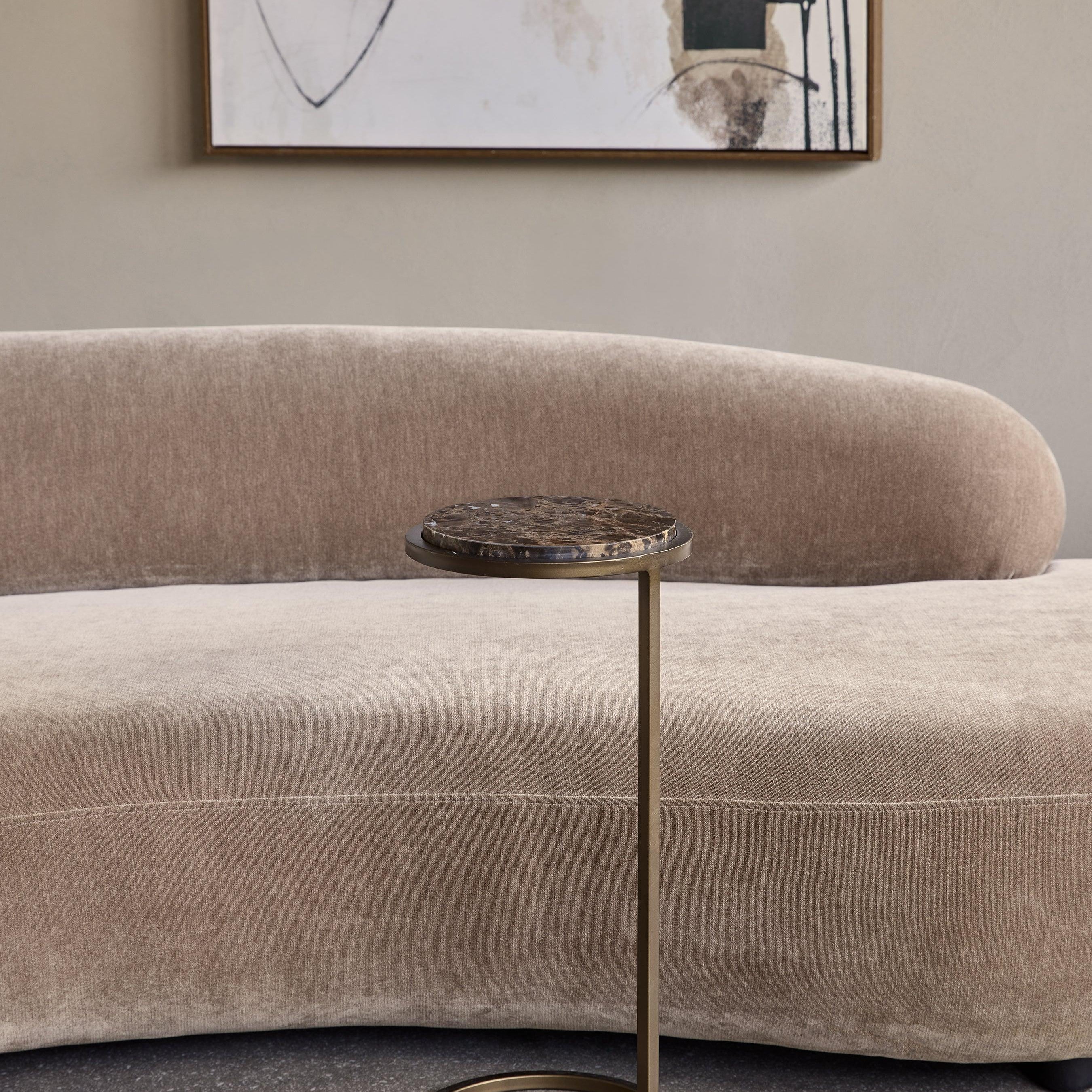 Brown marble accent table beside a beige sofa in a modern living room.
