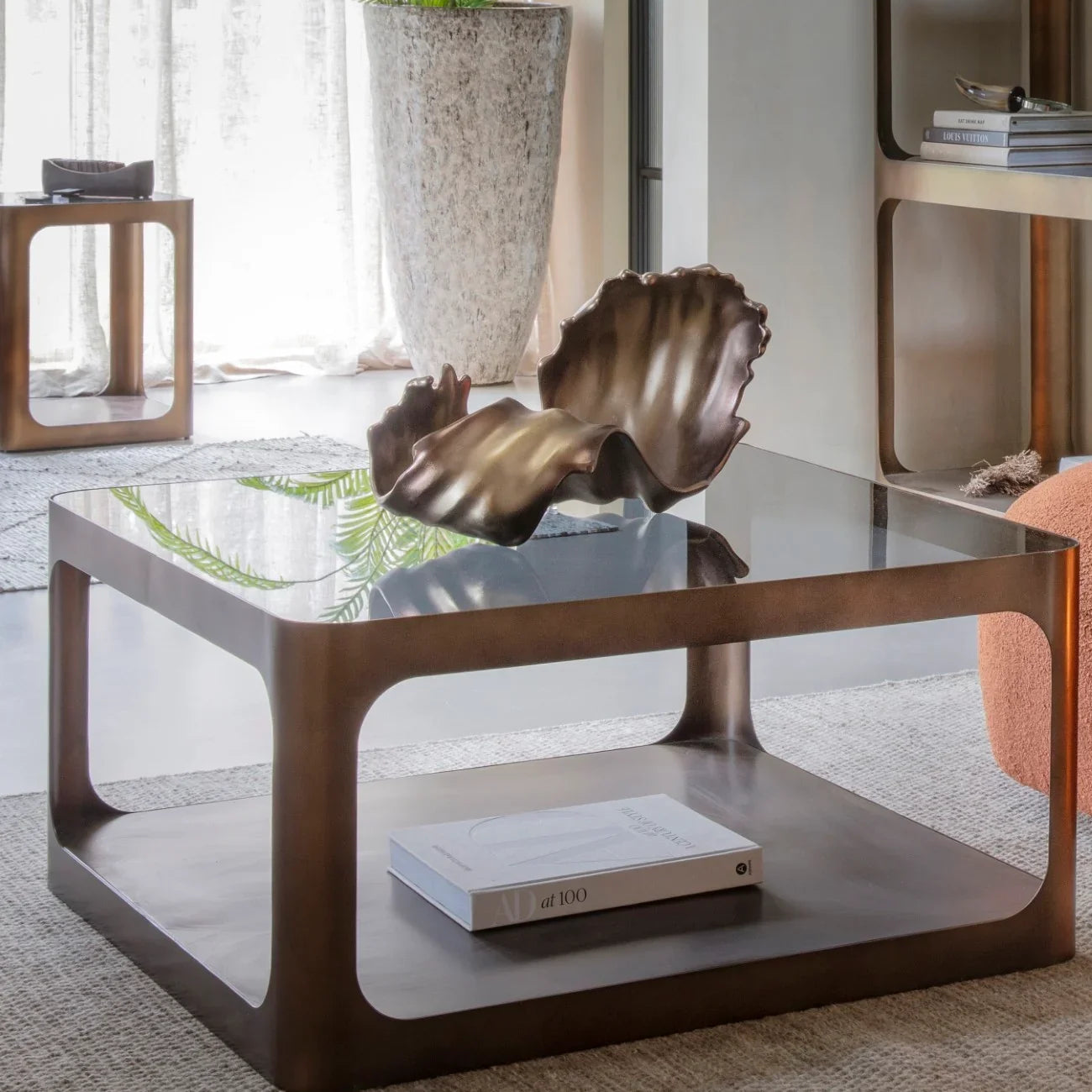 Brown metal and glass coffee table in a modern living room setting.