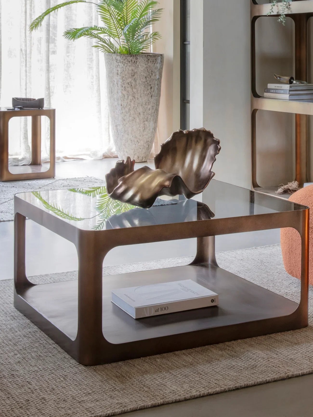 Brown metal and glass coffee table in a modern living room setting.