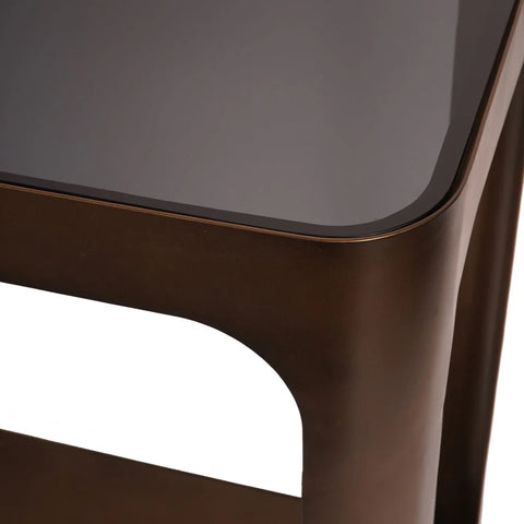 Bronze metal console table corner with dark glass top.