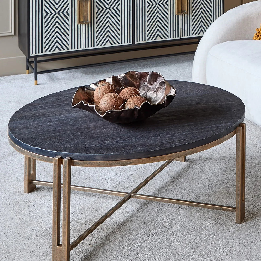 Black wood coffee table with champagne frame in modern living room setting.