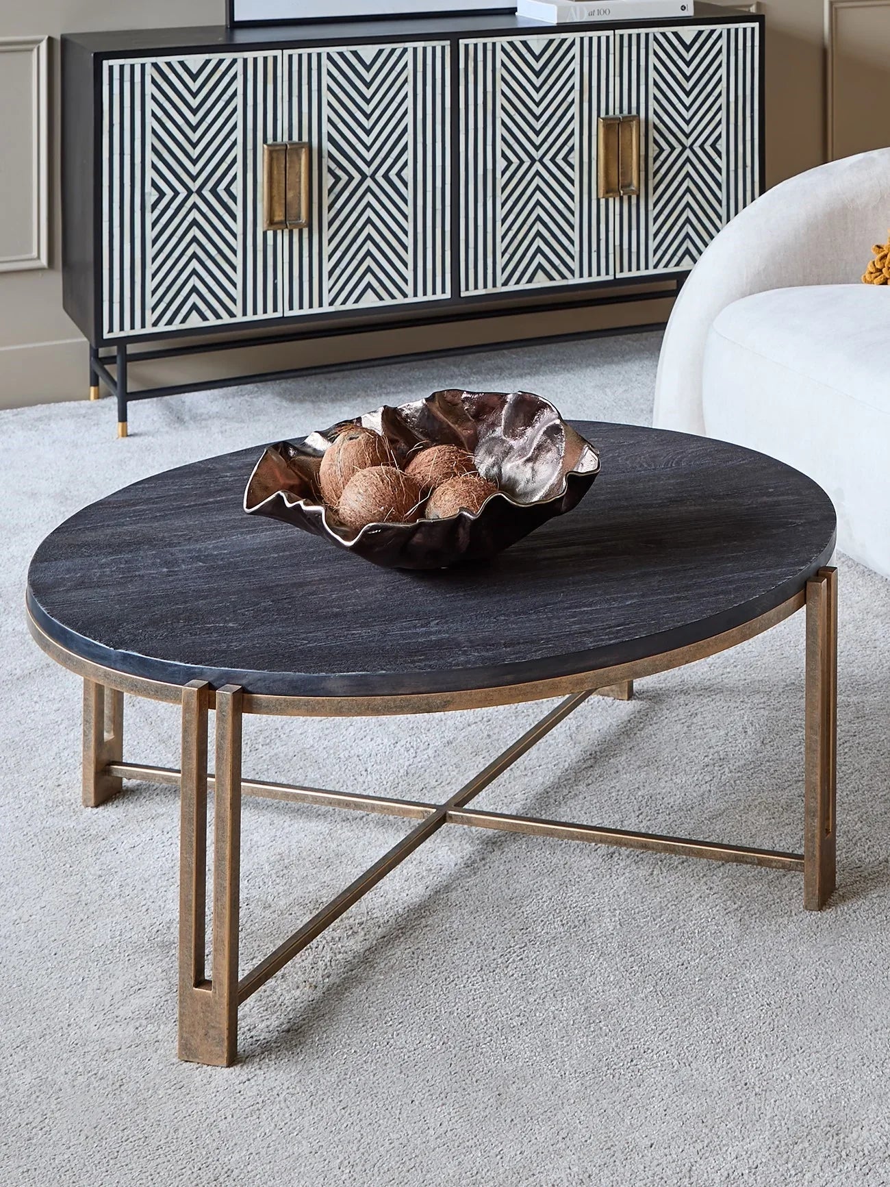 Black wood coffee table with champagne frame in modern living room setting.