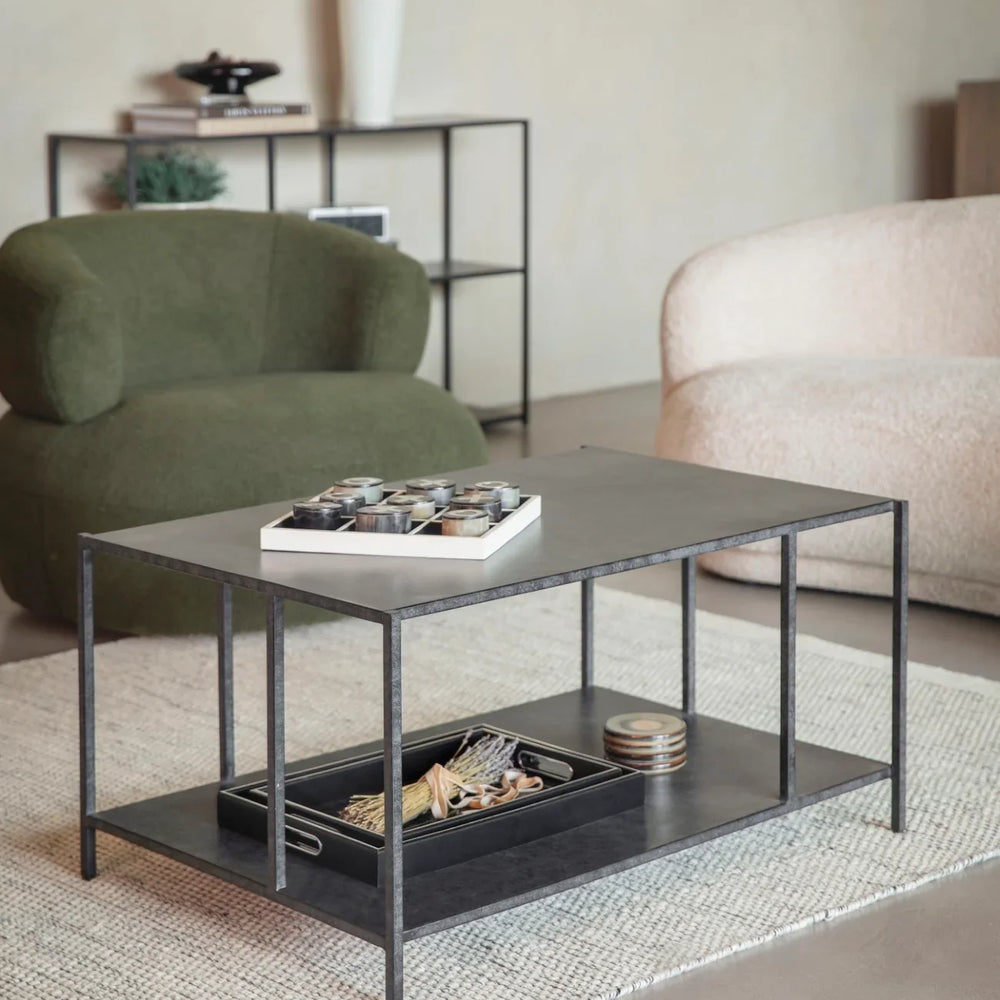 Mottled black coffee table in cozy living room with green and beige chairs.