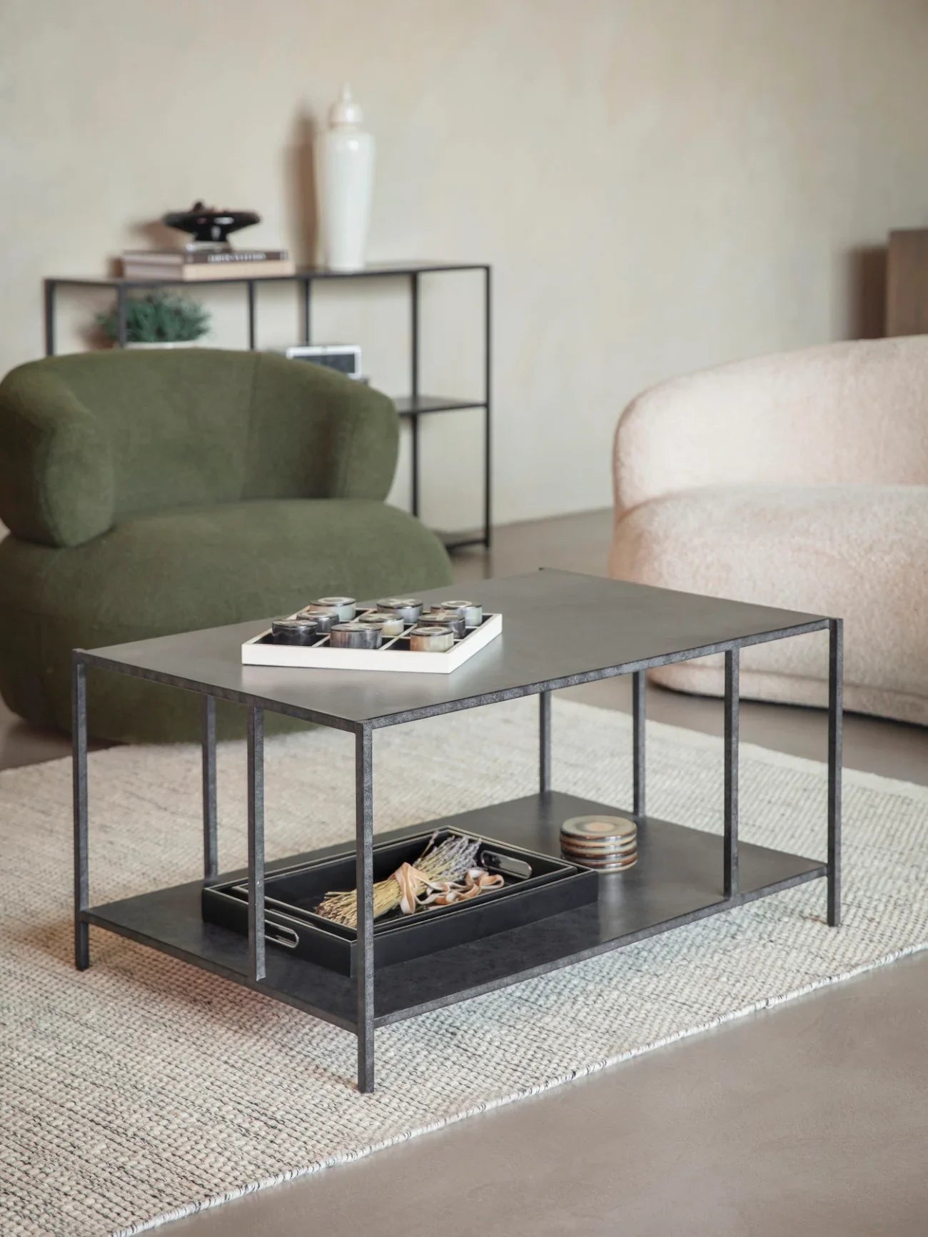 Mottled black coffee table in cozy living room with green and beige chairs.