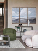 Console table in a modern living room with green and beige seating and abstract wall art.