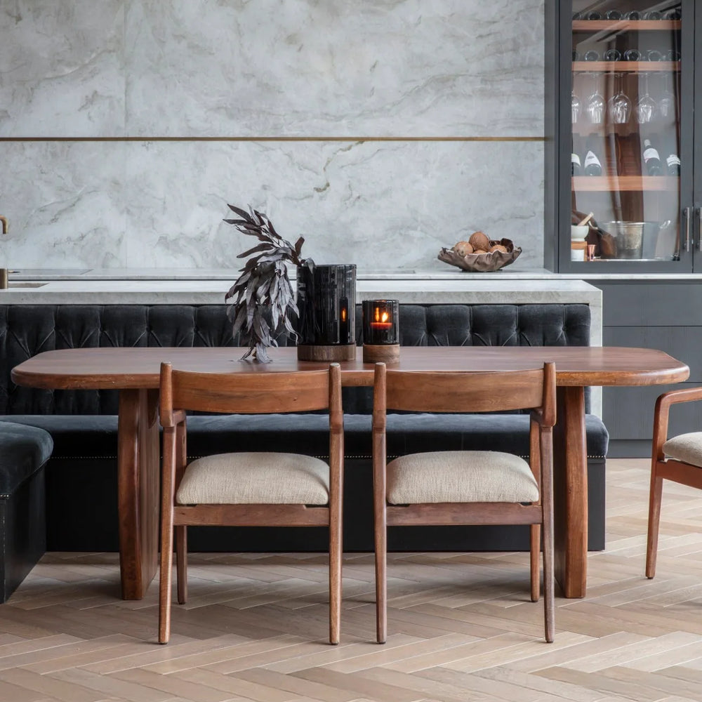 Wooden dining table with chairs in a modern dining room setting.