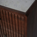 Dark wood chest corner with vertical grooves and smooth marble top.