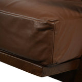 Brown leather armchair cushion with visible stitching detail.