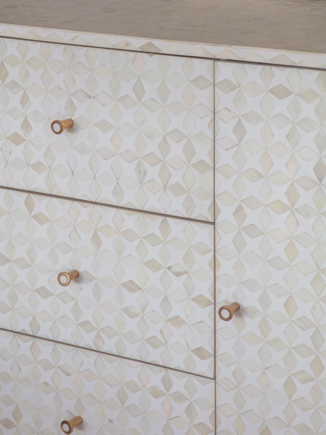 White geometric patterned sideboard with wooden knobs.