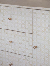 White geometric patterned sideboard with wooden knobs.