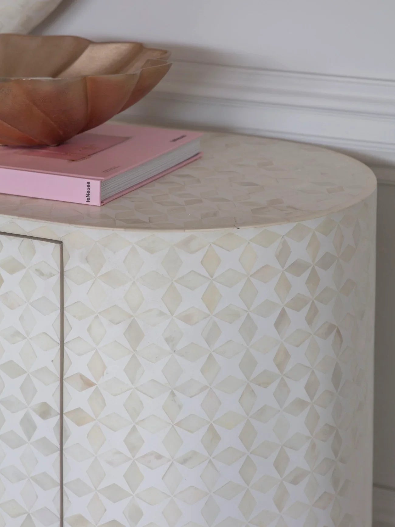Cream bone inlay sideboard with geometric pattern and decorative bowl on top.