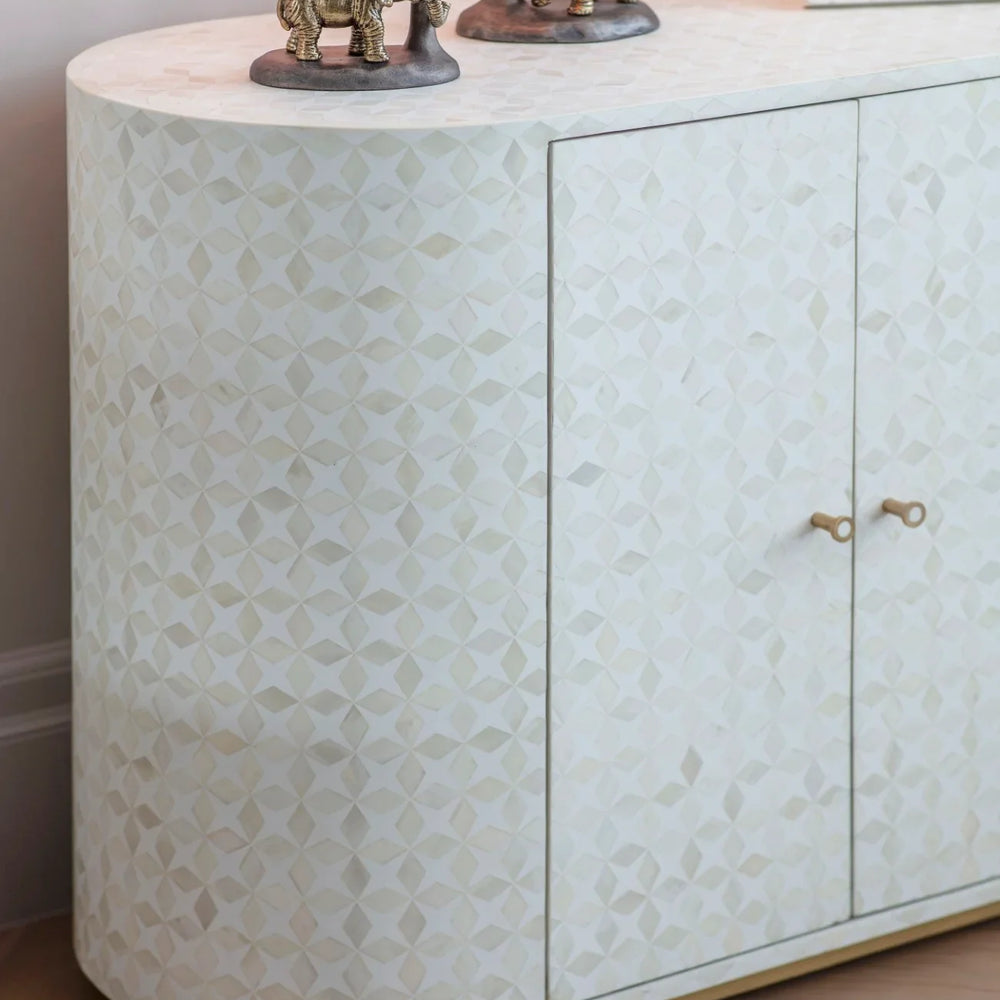 White bone inlay cabinet with geometric pattern and decorative elephant figures on top.