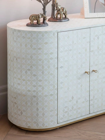 White bone inlay cabinet with geometric pattern and decorative elephant figures on top.