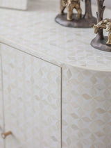 White geometric pattern on cabinet surface with decorative figurines.