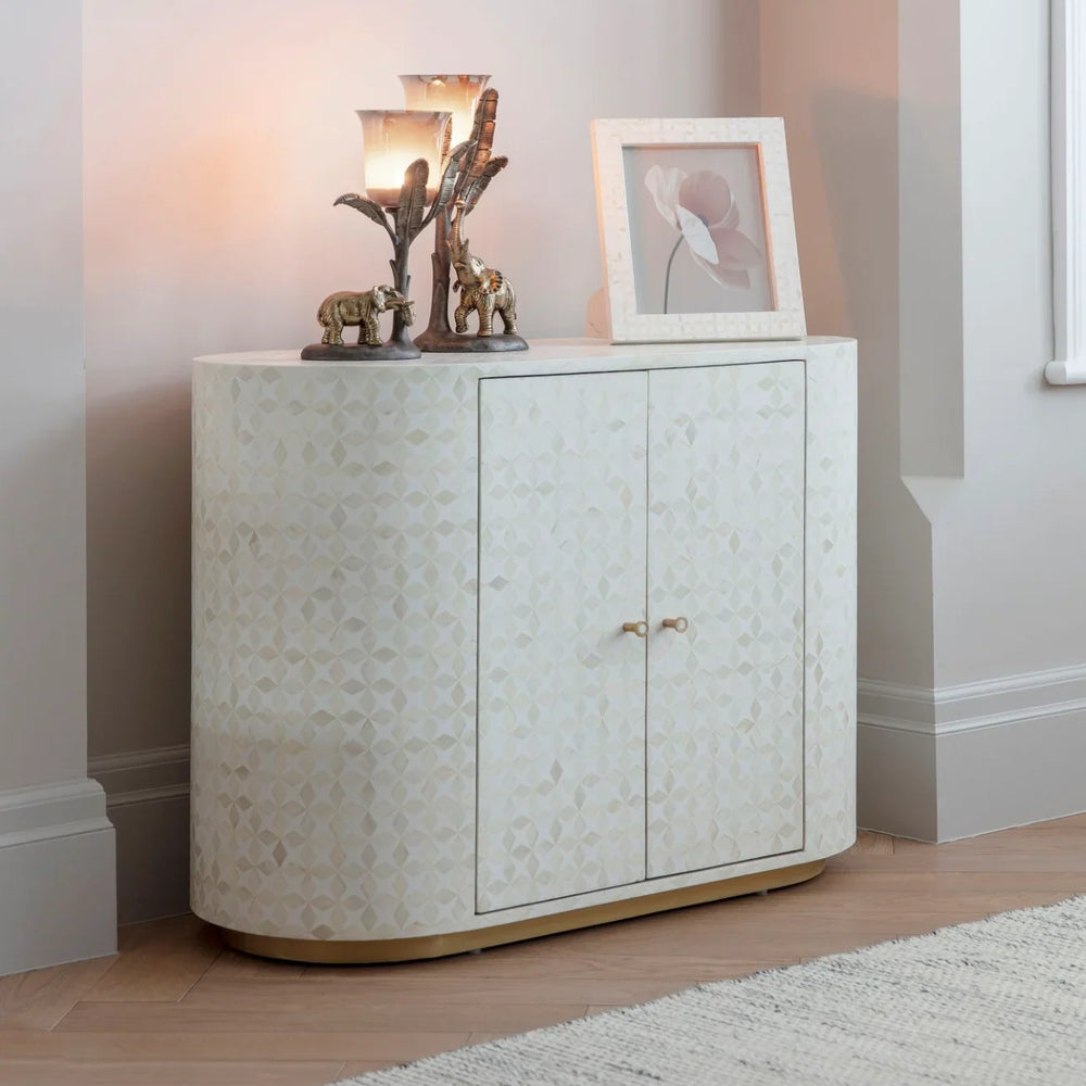 Cream inlay cabinet in cozy room with decorative items on top.