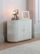 Cream inlay cabinet in cozy room with decorative items on top.