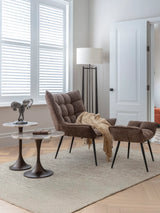 Two round stone-topped tables in a cozy living room with a brown armchair.