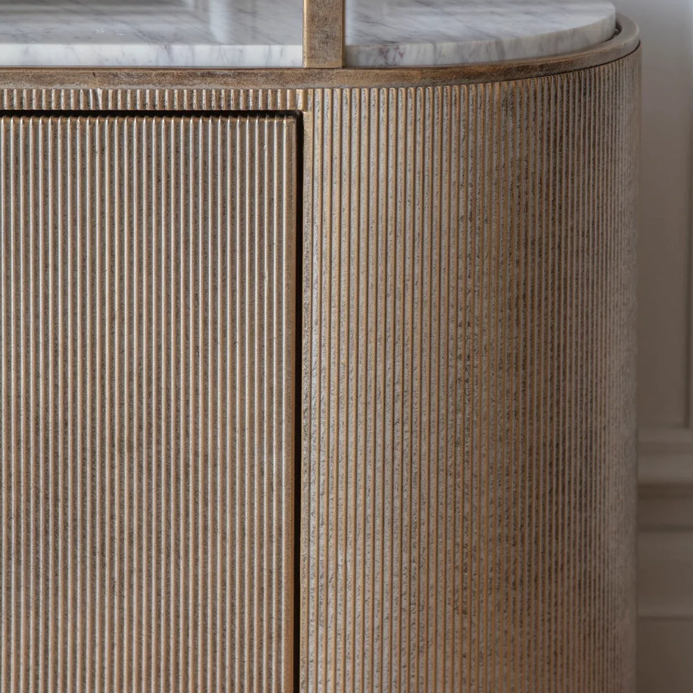 Ribbed aged gold shelving unit with marble top detail.
