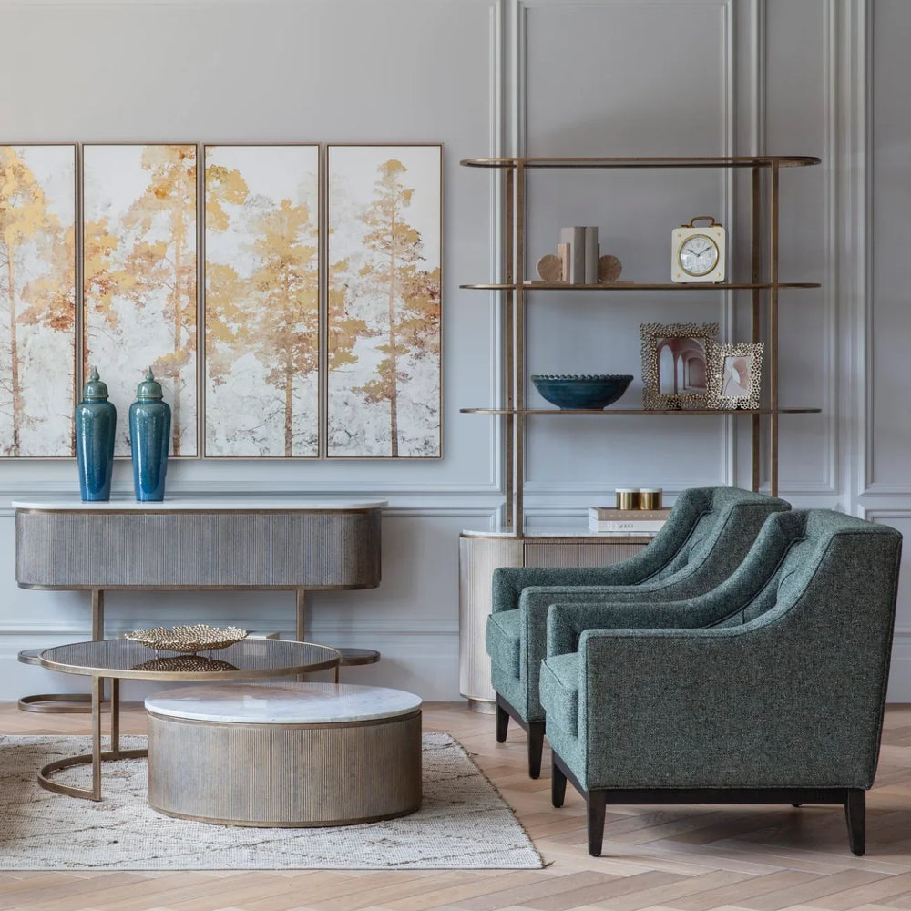 Aged gold shelving unit in elegant living room with teal armchairs.