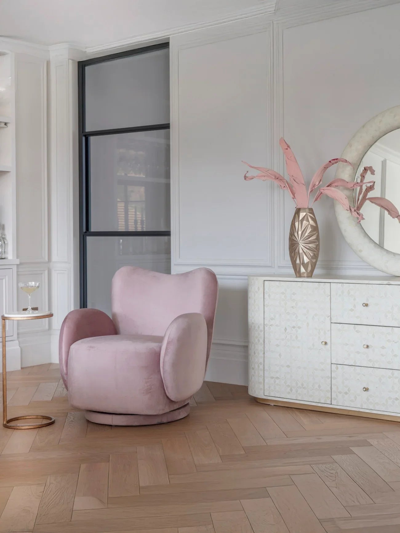 Dusky pink velvet swivel chair in elegant living room with modern decor.