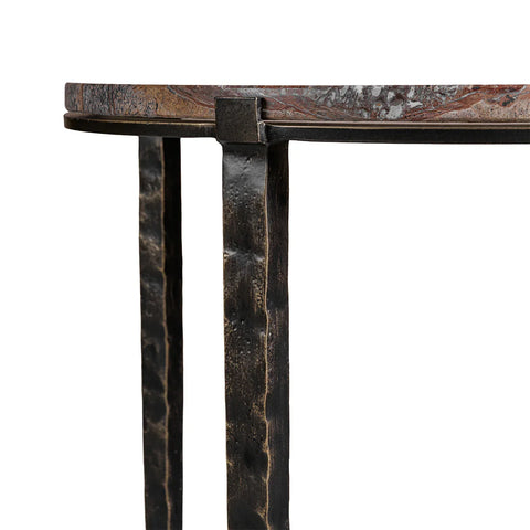 Textured metal legs supporting a round brown marble tabletop.