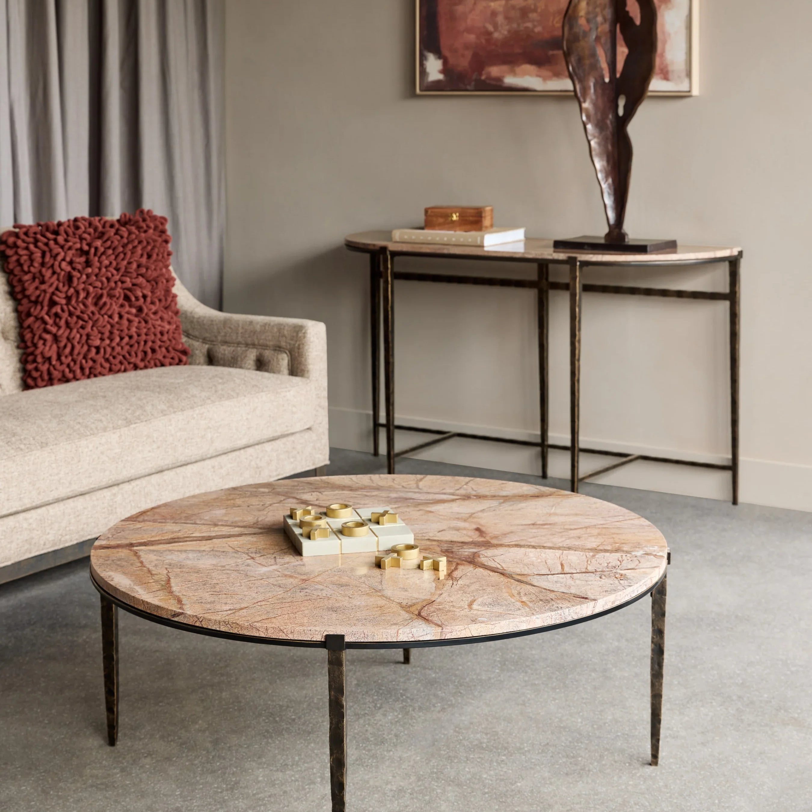 Round brown marble coffee table in a modern living room with a beige sofa.