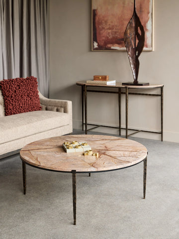 Round brown marble coffee table in a modern living room with a beige sofa.
