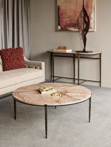 Round brown marble coffee table in a modern living room with a beige sofa.