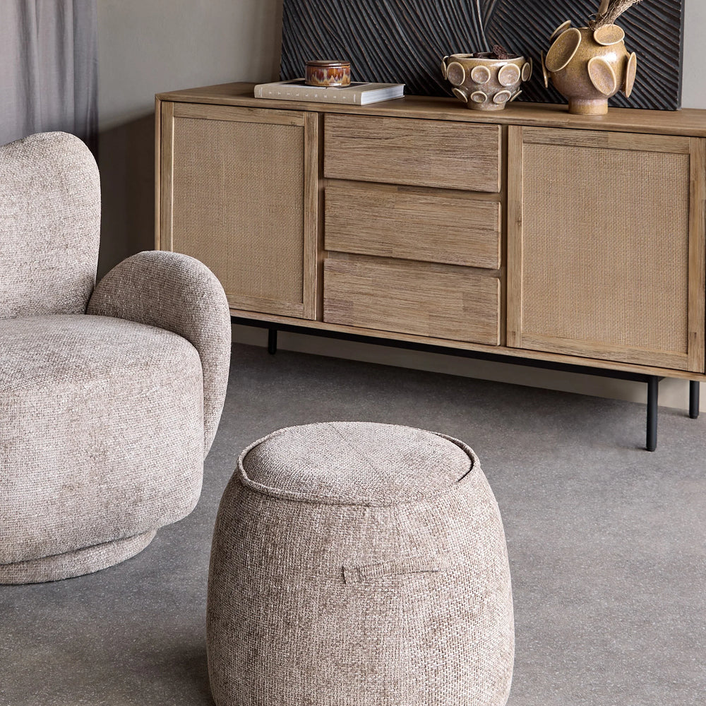 Beige textured stool in a cozy living room with a wooden sideboard.