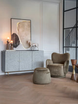 Velvet green stool in elegant living room with armchair and sideboard.