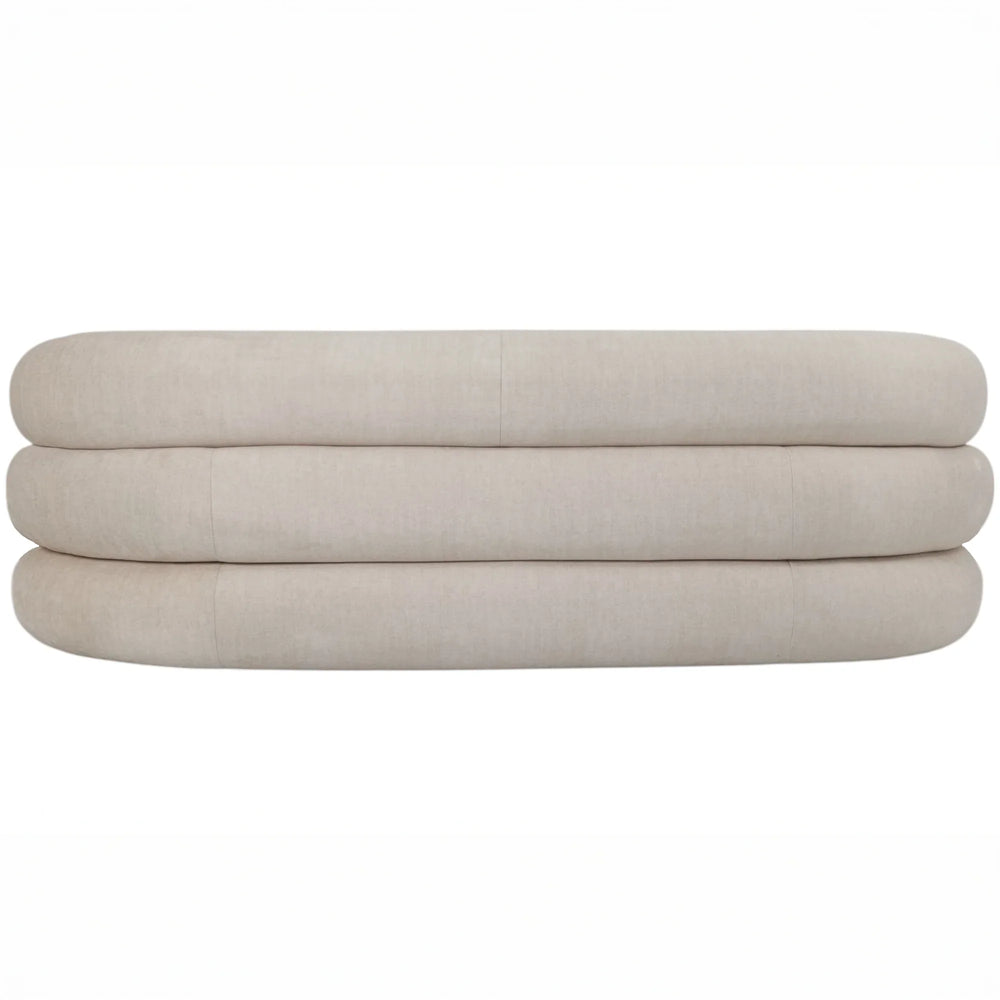 Cream sofa backrest with rounded, layered cushions.