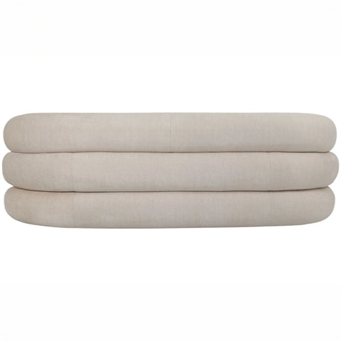 Cream sofa backrest with rounded, layered cushions.