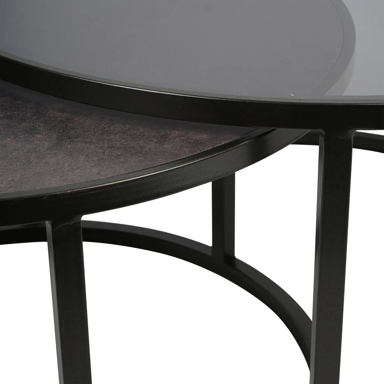 Black nesting tables with round metal frames and glass tops.