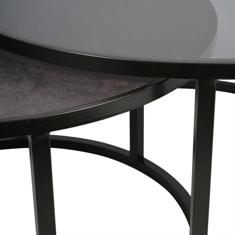 Black nesting tables with round metal frames and glass tops.