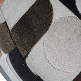 Textured close-up of patterned velvet fabric in earthy tones.