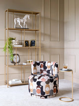 Patterned velvet swivel chair in elegant living room with gold shelving.