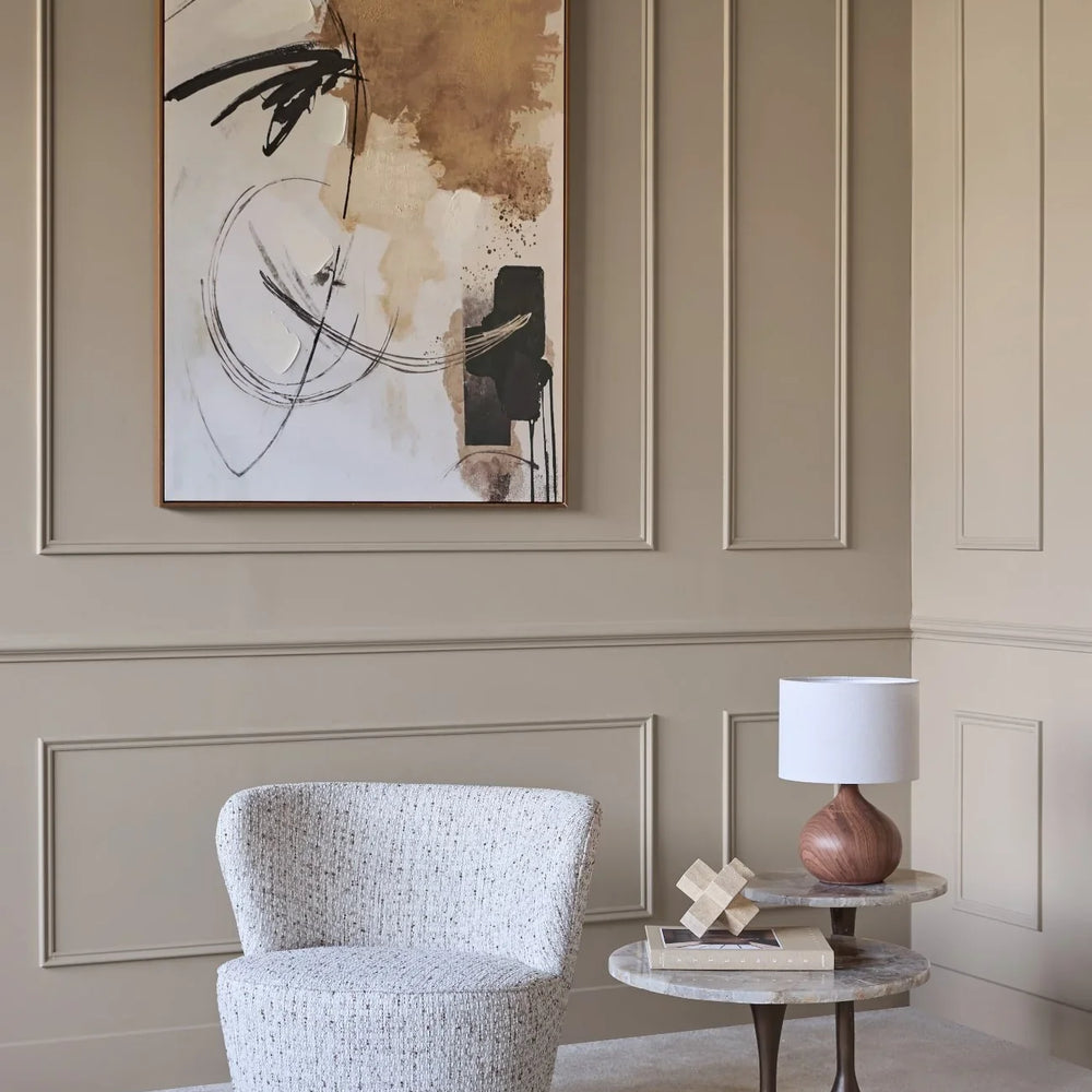 Textured natural swivel chair in elegant living room with abstract art.