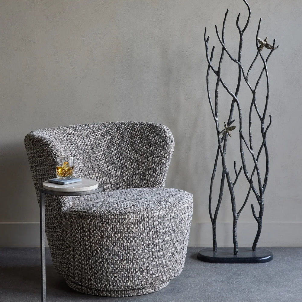 Mocha textured swivel chair with side table and decorative branches.