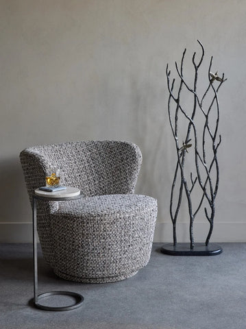 Mocha textured swivel chair with side table and decorative branches.